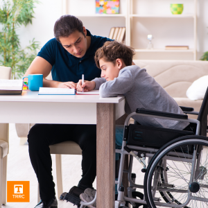 student in a wheelchair, getting help from a tutor or father figure