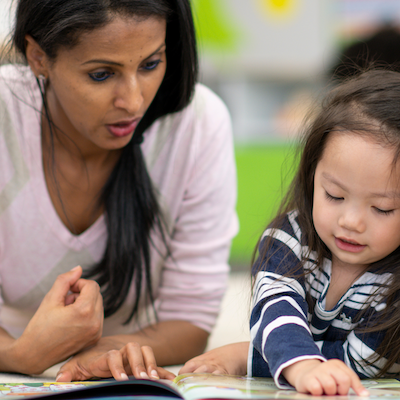 an adult with a child reading a book